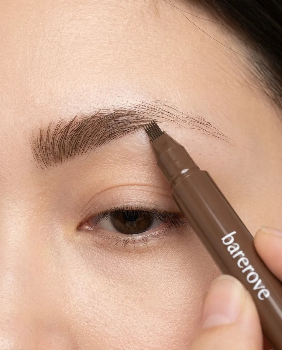 The fine-forked tip building the sparse side of a brow back, stroke by stroke