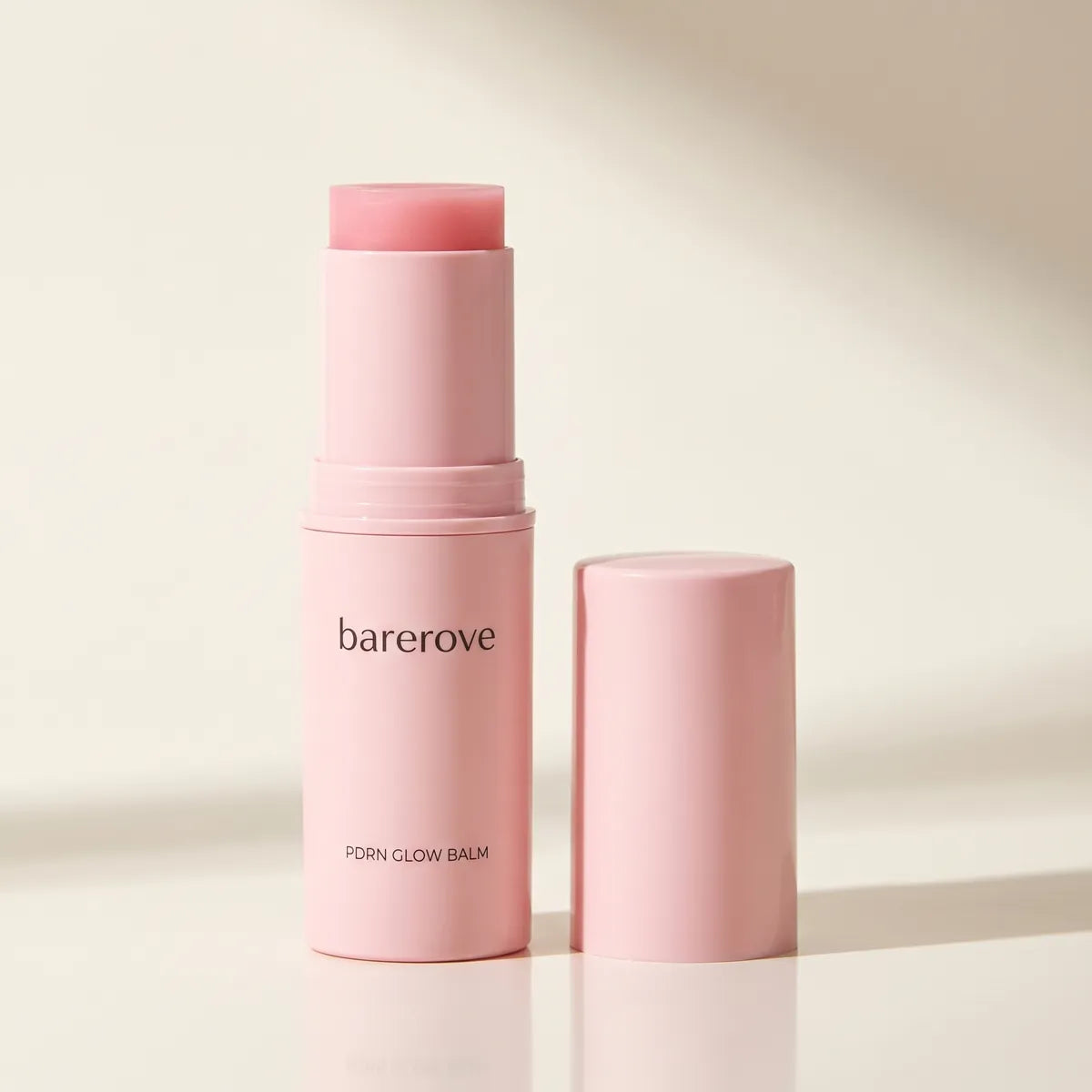 The pink PDRN balm stick twisted up on white