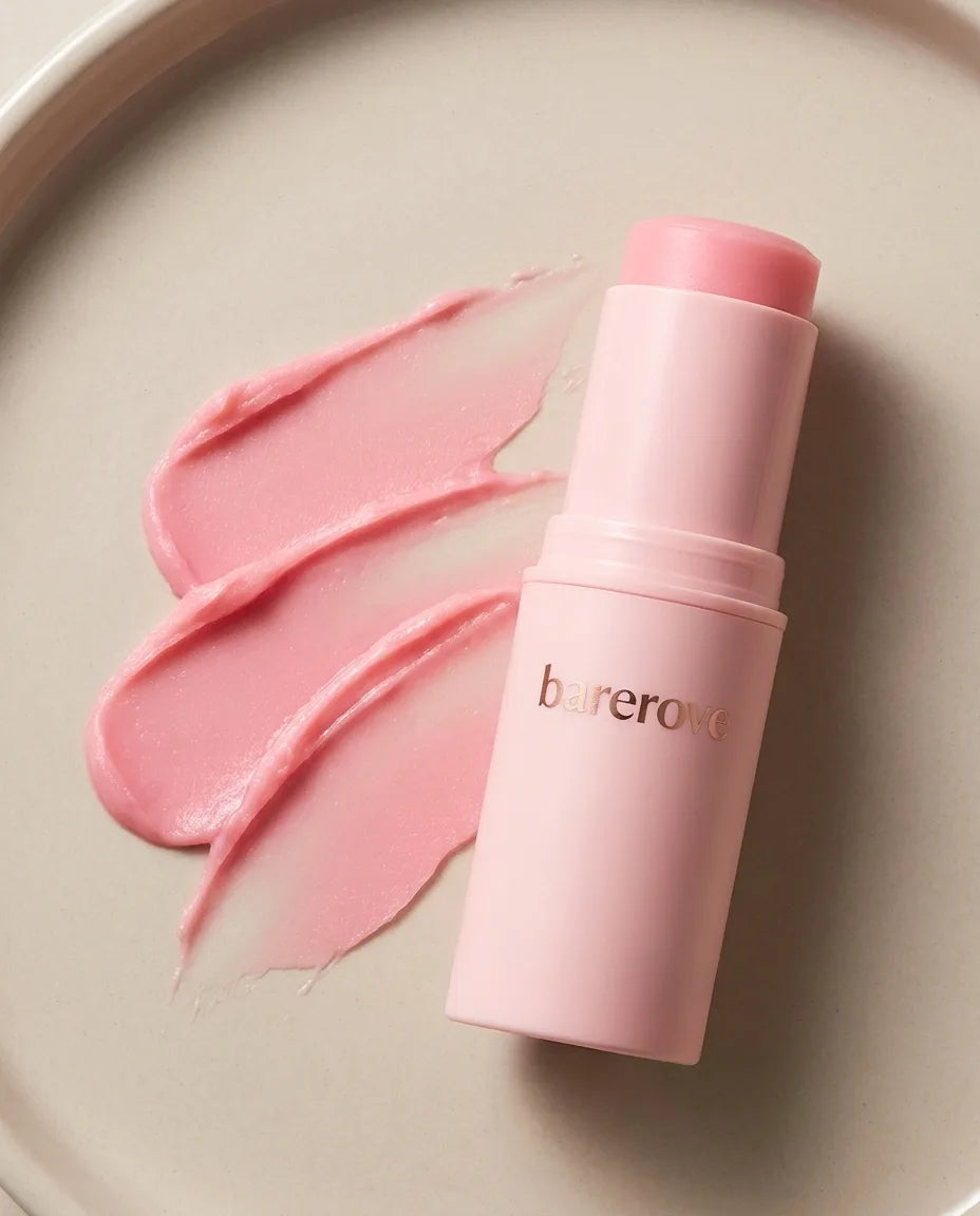 A pink balm swatch smeared on skin to show the color and texture
