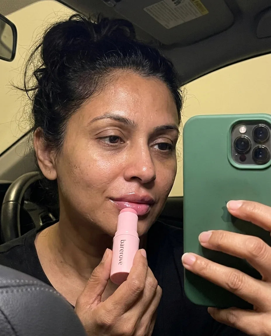 customer applying the balm stick to her lips in her car